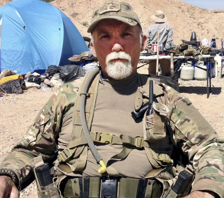 Gerald “Jerry” DeLemus of Rochester, N.H., sits among a group of militia members camping on Cliven Bundy’s ranch near Bunkerville, Nev., in 2014.(photo the Associated Press)