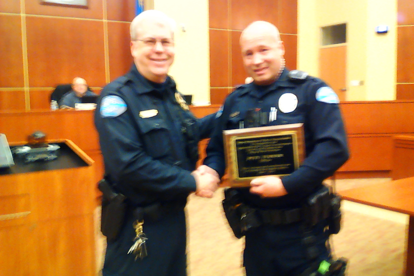Police Officer Pete Turner receiving a recognition plaque for 10 Years of Service from Police Chief Burdel Welsh.